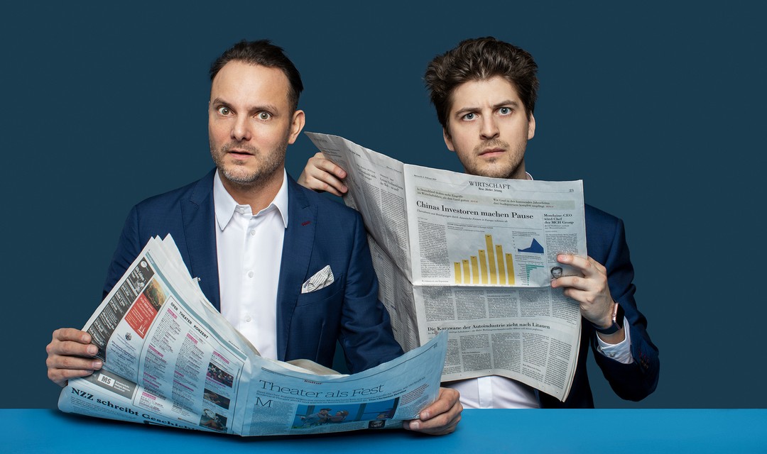 Dominic Deville und sein Sidekick Patrick Karpiczenko lesen Zeitung