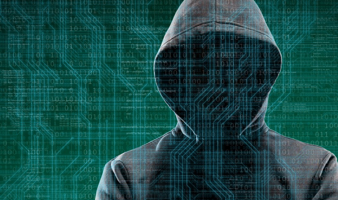 Ein vermummter Hacker mit Programmiercodes im Hintergrund