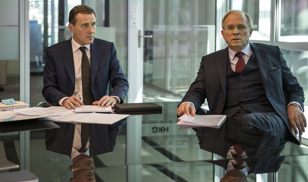 Alexander Maier und Hans-Werner Brockmann sitzen nebeneinander an einem Glastisch im Büro